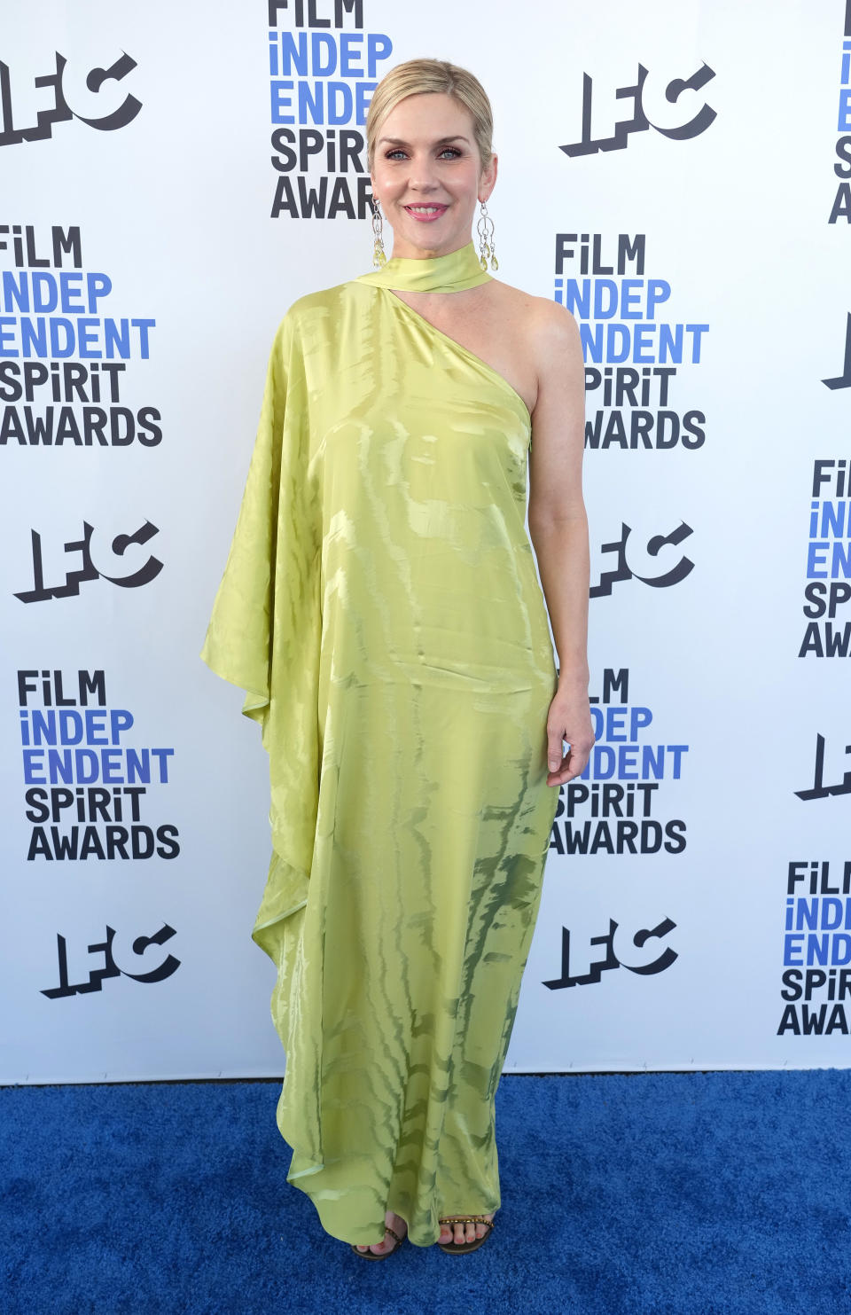 Rhea wears a light green one shoulder silk dress