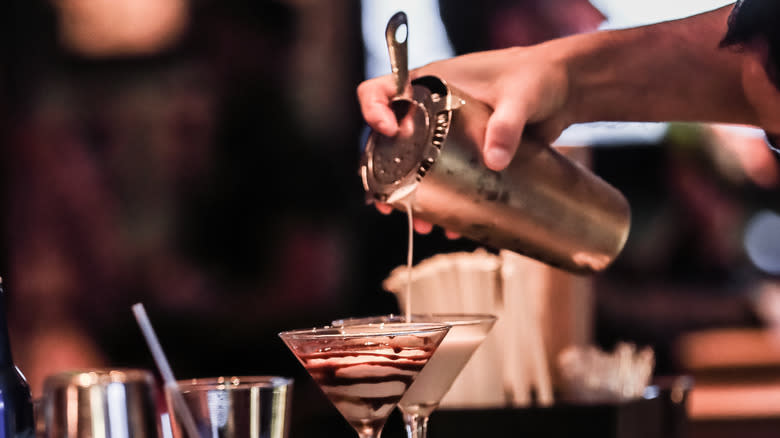 pouring cocktail with Hawthorne strainer