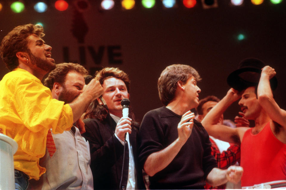 Pop stars singing during the finale of the Live Aid concert at Wembley Stadium: (L-R) George Michael, promoter Harvey Goldstein, Bono (lead singer of U2), Paul McCartney and Freddie Mercury (lead singer of Queen).