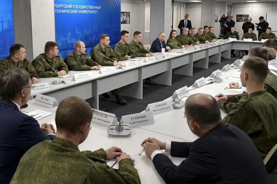 Russian President Vladimir Putin, centre right, talks with Russian servicemen during his visit to the Saint Petersburg State Maritime Technical University in St. Petersburg, Russia, Friday, Jan. 26, 2024. (Alexei Danichev, Sputnik, Kremlin Pool Photo via AP)