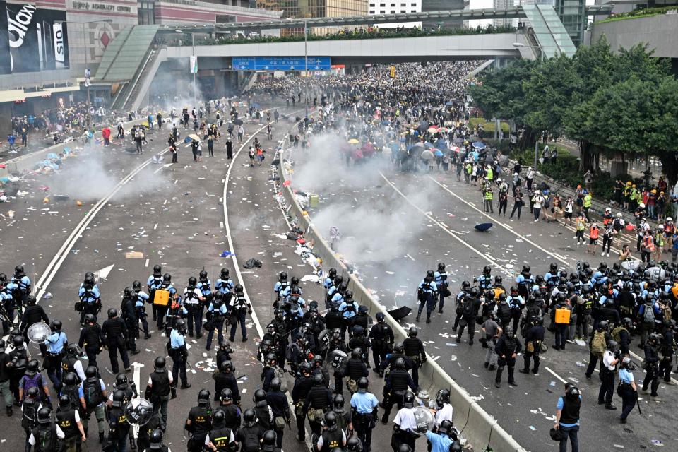 Protesters retreat  after police fired tear gas during a rally against a controversial extradition law proposal in Hong Kong on June 12, 2019.
