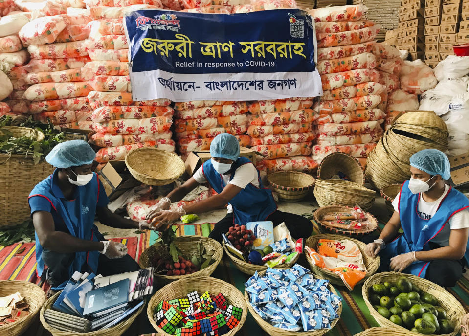Members of Bidyanondo Foundation pack care packages for COVID-19 patients in Dhaka, Bangladesh, Saturday, June 6, 2020. The Bangladeshi group of volunteers is providing COVID-19 patients with fruit baskets and “get well soon” cards to keep their spirits up amid reports that many patients are being ostracized by their families and neighbors. The group stepped in after disturbing news reports that a woman has been abandoned in a forest by her family after she developed coronavirus symptoms. (AP Photo/Al-emrun Garjon)