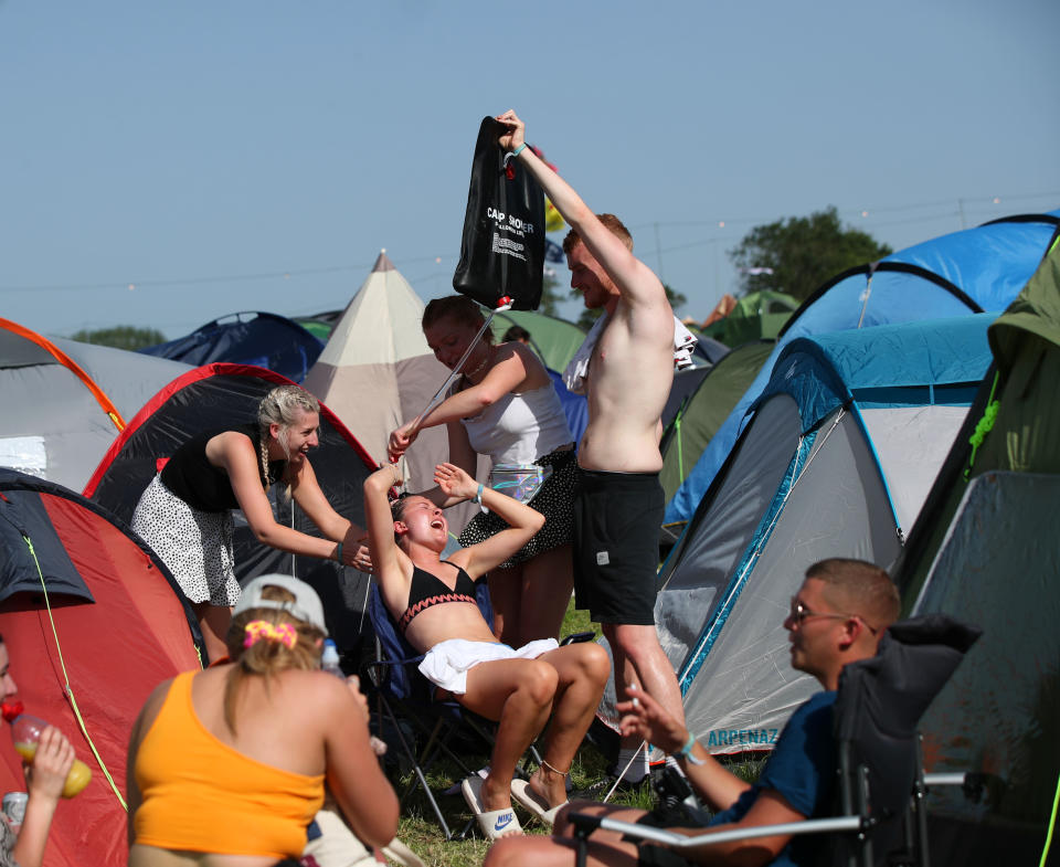 Festival goers enjoying the sun during Glastonbury Festival at Worthy Farm, Pilton, Somerset.