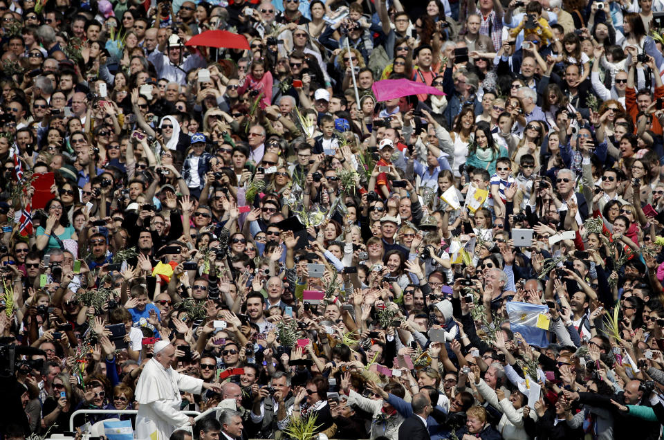 Pope Francis is cheered by a crowd of faithful at the end of a Palm Sunday service in St. Peter's Square, at the Vatican, Sunday, April 13, 2014. Pope Francis, marking Palm Sunday in a packed St. Peter's Square, ignored his prepared homily and spoke entirely off-the-cuff in a remarkable departure from practice. Later, he hopped off his popemobile to pose for "selfies" with young people in the crowd. In his homily, Francis called on people, himself included, to look into their own hearts to see how they are living their lives. (AP Photo/Gregorio Borgia)