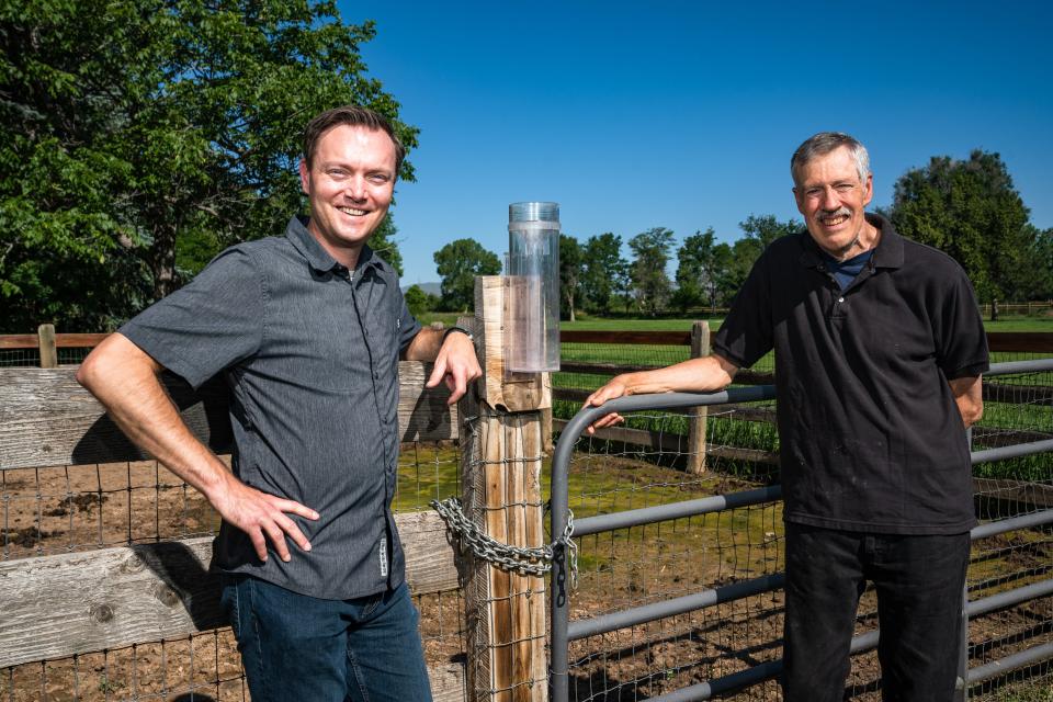 Colorado state climatologist Russ Schumacher, left, and former state climatologist Nolan Doesken pose for a photo beside a rain gauge at Doesken's Fort Collins home on July 12. Doesken founded the Community Collaborative Rain, Hail and Snow Network, which has volunteers record and report daily precipitation, 25 years ago.