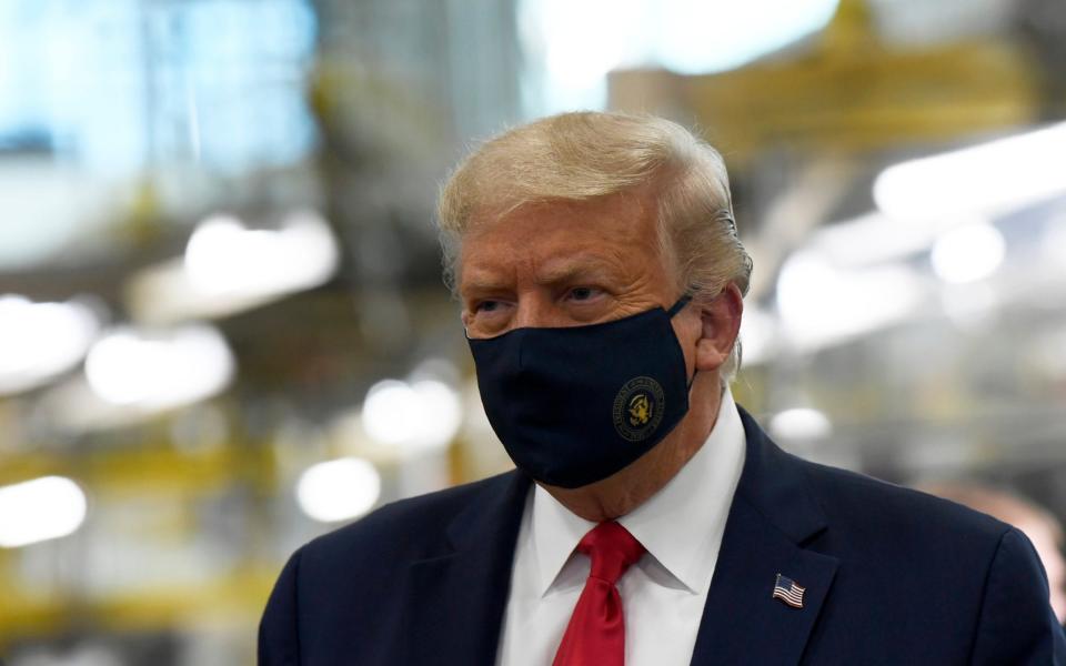 Donald Trump pictured wearing a face mask  - AP
