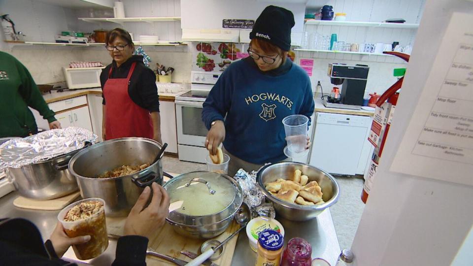 Ida Bird, right, grabs bannock from a bowl in the kitchen of the Nipawin Oasis.