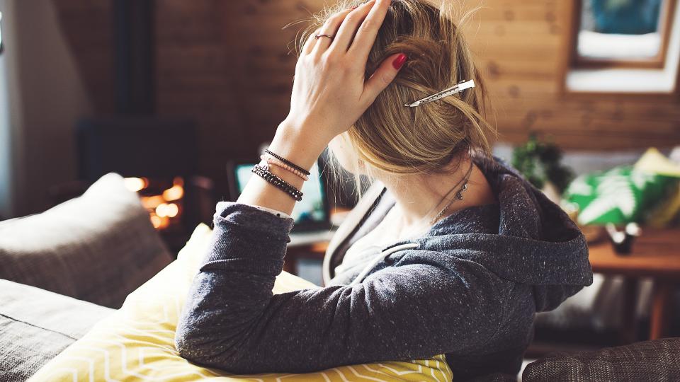 Woman at home looking away showing back of head.