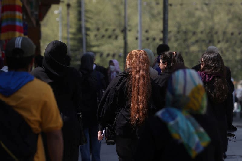 FILE PHOTO: People walk on a street amid the implementation of the new hijab surveillance in Tehran