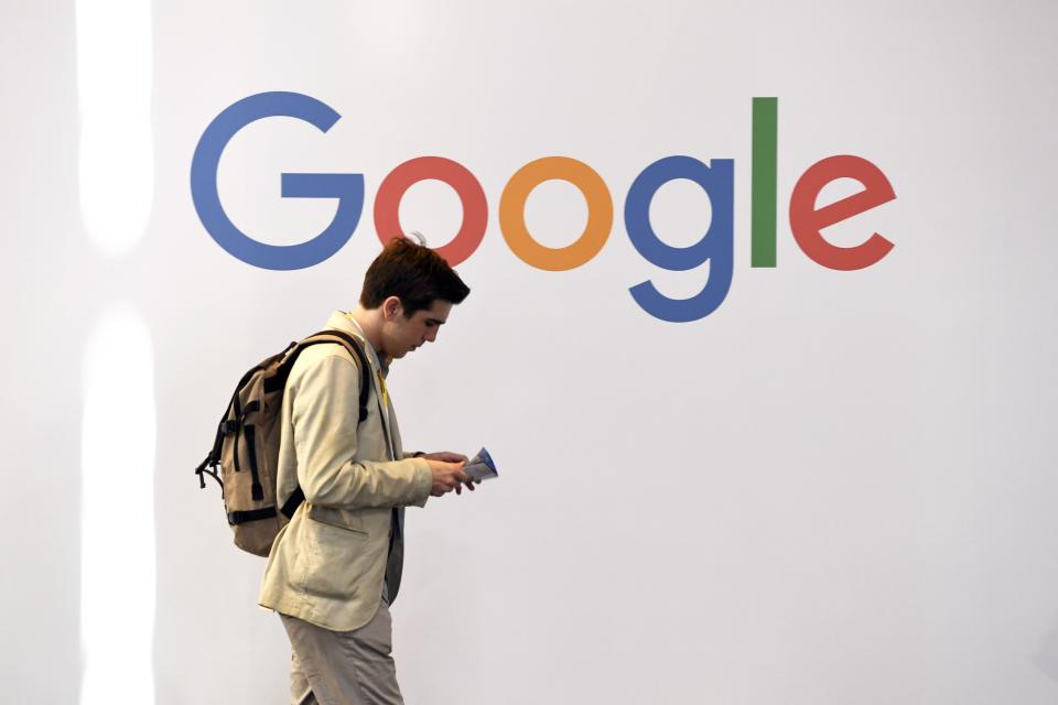 Man walking past Google logo