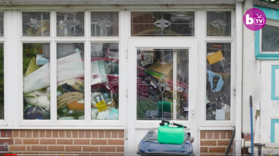 Junk is piled high against the windows of Michael's home. Source: Barcroft