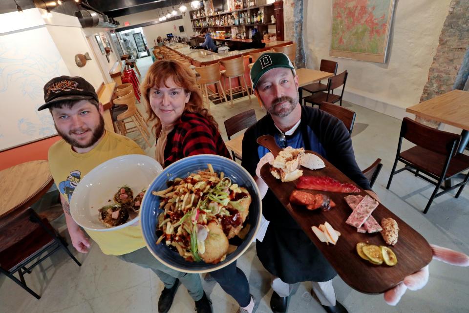 Joshua Lemaire holds up Oyster Rockefeller, wife Amelia Ruvich holds Dirty Fish & Chips while chef Chris Cronin holds up a Land & Sea Board at the newly opened Union Flats restaurant at 37 Union Street in downtown New Bedford.