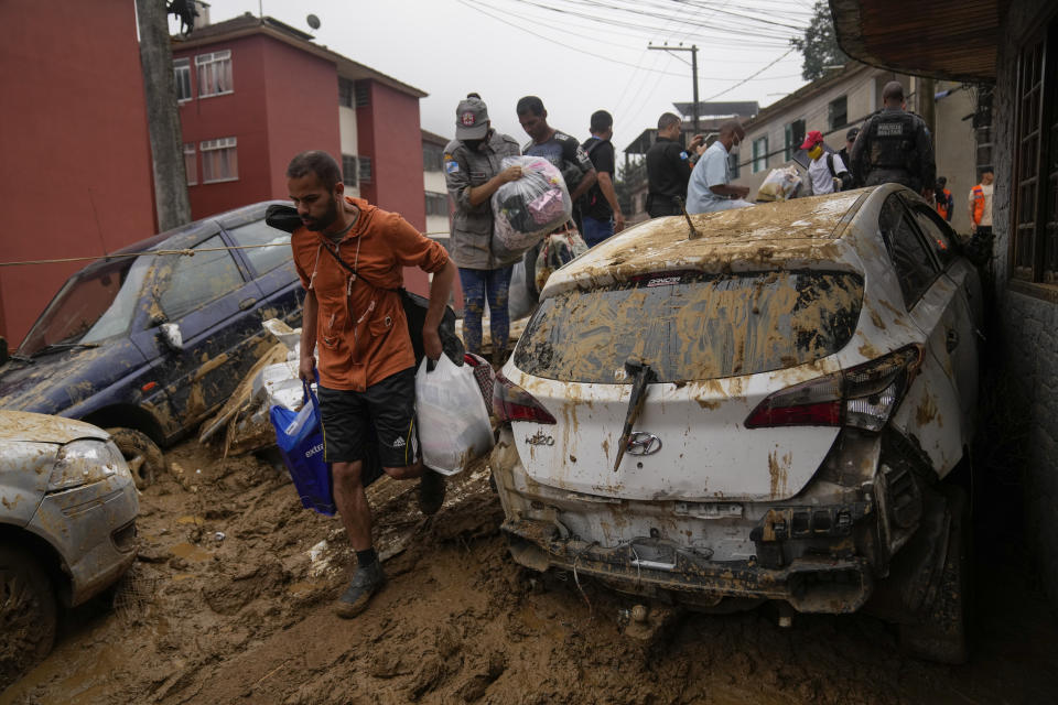 Residents recover belongs from thier homes destroyed by mudslides in Petropolis, Brazil, Wednesday, Feb. 16, 2022. Extremely heavy rains set off mudslides and floods in a mountainous region of Rio de Janeiro state, killing multiple people, authorities reported. (AP Photo/Silvia Izquierdo)