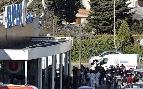 French security and police gather outside the Super U supermarket in the town of Trebes, southern France, where a man took hostages killing at least two before he was killed by security forces on March 23, 2018. - Credit: PASCAL PAVANI/AFP