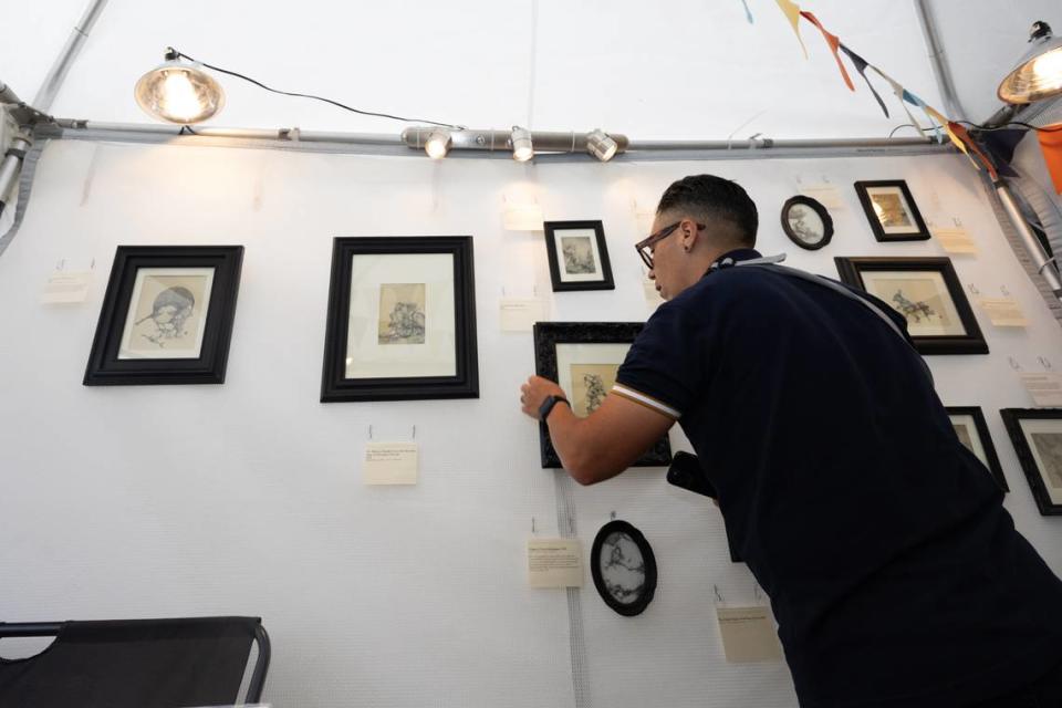 Artist Rob Bridges fixes his illustrations during the first day of Belleville’s famous Art on the Square on May 17, 2024.