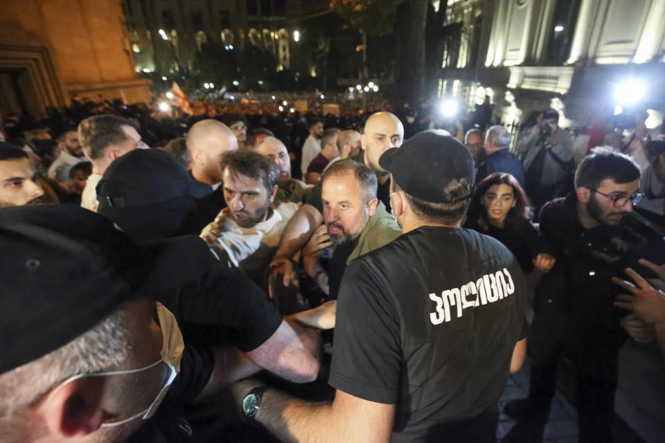 Opposition protesters who gather to protest against "the Russian law" try to brake through a police line in Tbilisi, Georgia, on Tuesday, April 30, 2024. Clashes erupted between police and opposition demonstrators protesting a new bill intended to track foreign influence that the opposition denounced as Russia-inspired. (AP Photo/Zurab Tsertsvadze)