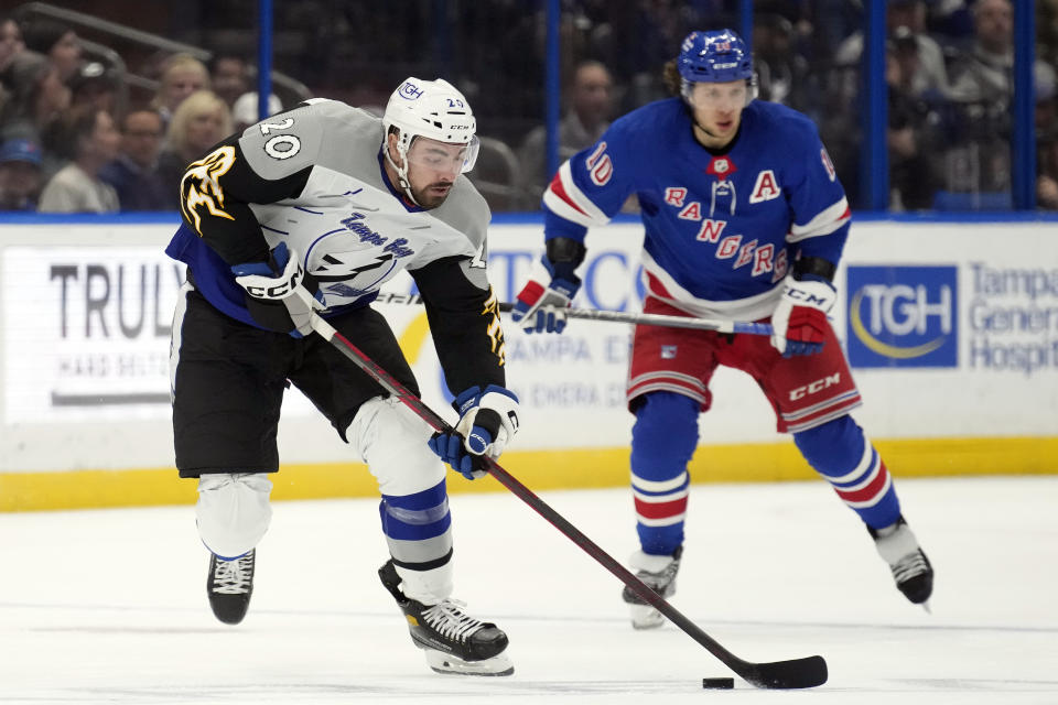 Tampa Bay Lightning left wing Nicholas Paul (20) breaks out ahead of New York Rangers left wing Artemi Panarin (10) during the second period of an NHL hockey game Thursday, Dec. 29, 2022, in Tampa, Fla. (AP Photo/Chris O'Meara)