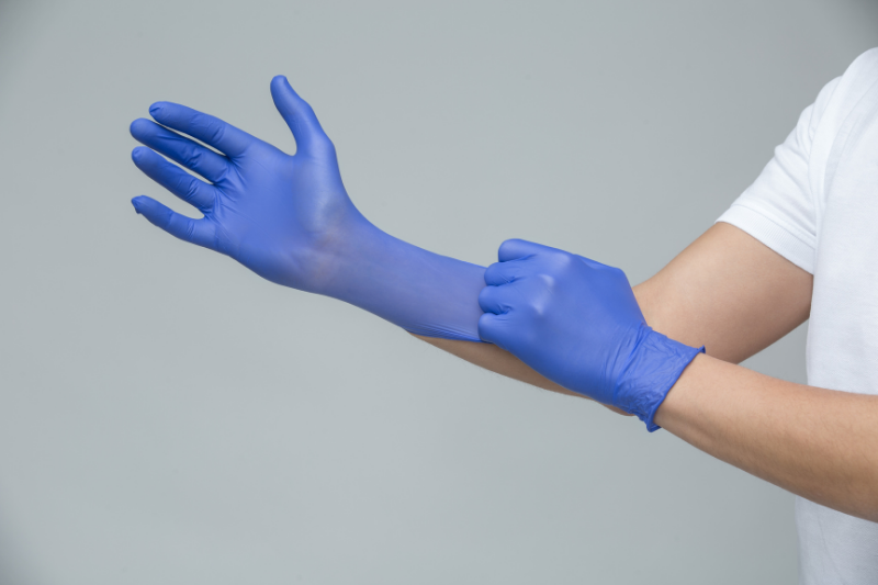 Person Putting on Disposable Gloves