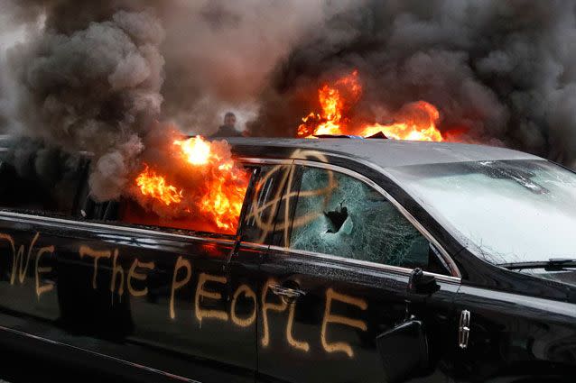 'We the people': Anarchists smash and burn a limo in the capital's streets. Source: AP