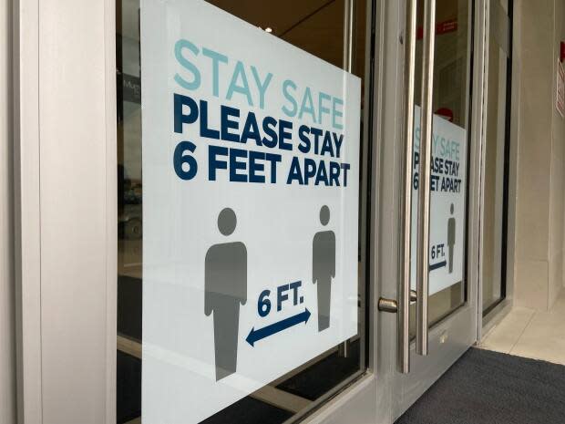 A sign on a door instructs people to stay six feet apart. Nova Scotia reported 25 new cases of COVID-19 on Tuesday. (CBC - image credit)