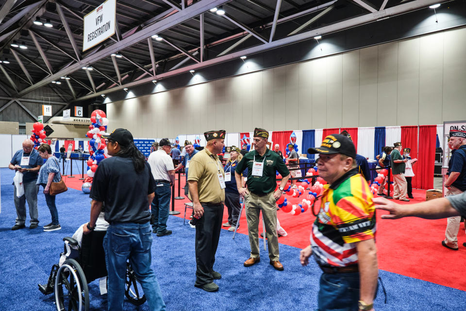 Michael Braman, center, speaks with Tom McClernon on the floor of the VFW Convention in Kansas City, Mo., on July 16, 2022. (Dominick Williams for NBC News)