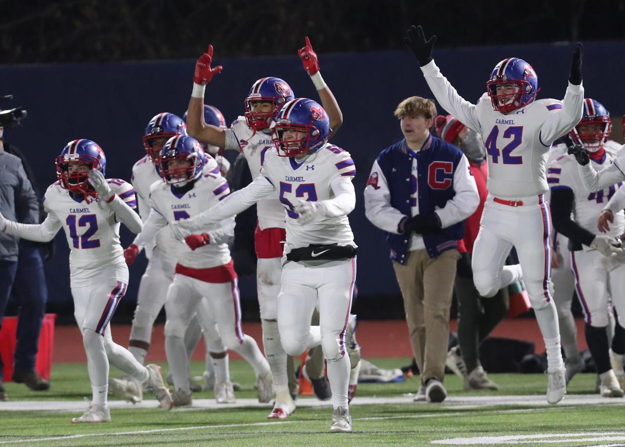 Carmel players celebrate their victory over Christian Brothers Academy in the Class AA state semifinal playoff game at Middletown High School Nov. 25, 2023.