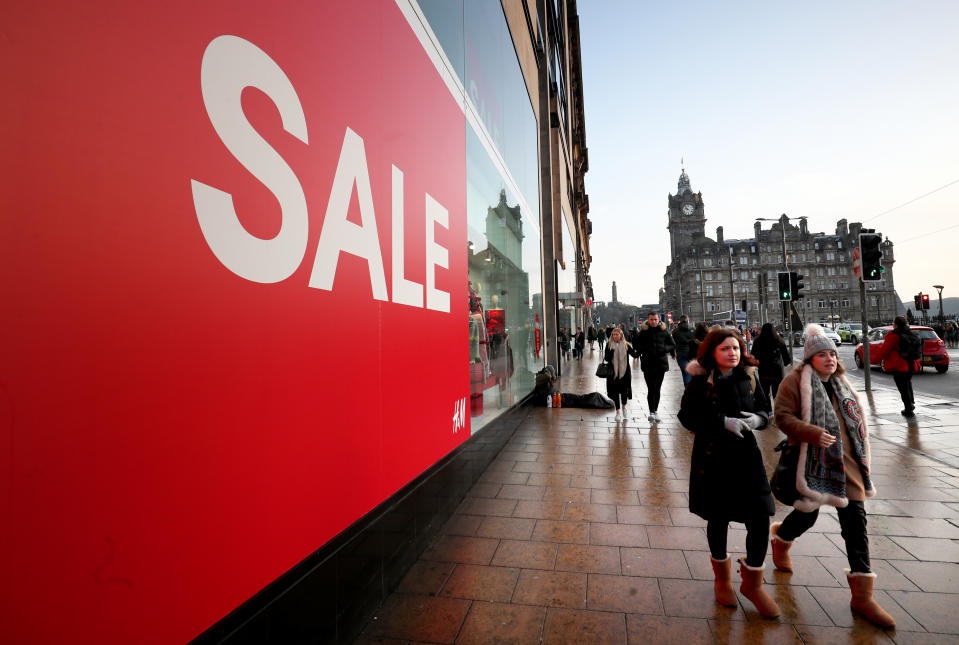 Shoppers pass a sale sign in the window of H&M on Princes Street, Edinburgh, during the Boxing Day sales.