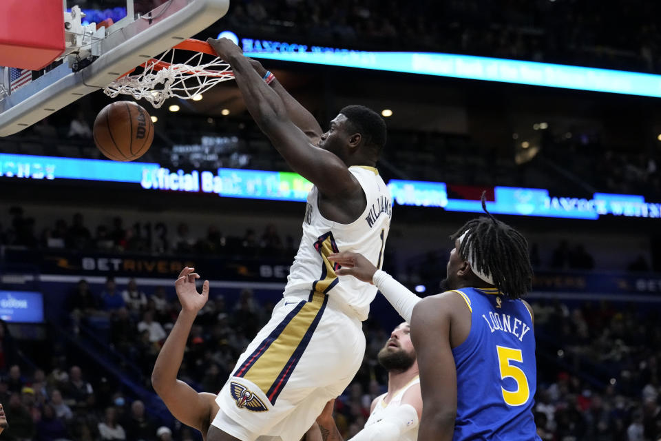 New Orleans Pelicans forward Zion Williamson (1) slam dunks over Golden State Warriors center Kevon Looney (5) in the first half of an NBA basketball game in New Orleans, Monday, Nov. 21, 2022. (AP Photo/Gerald Herbert)