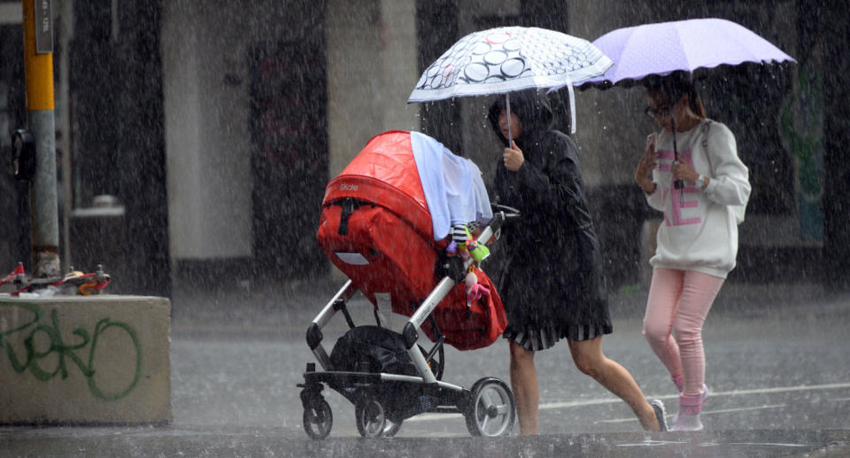 Pedestrians walk through the rain in Sydney’s CBD. Source: Getty Images