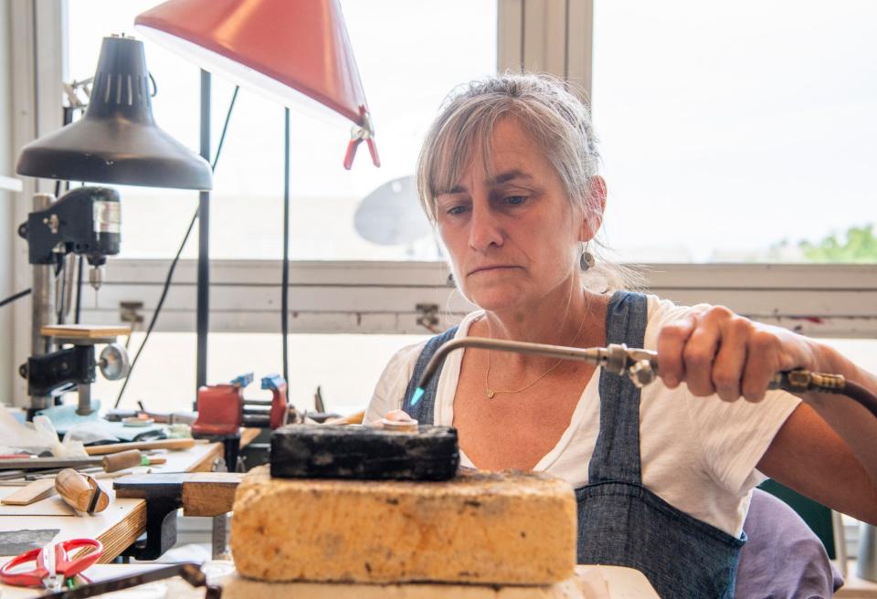 Nicole Jacquard heats a piece of jewelry she is working on inside her studio at the Eskenazi School of Art, Architecture + Design at Indiana University on Wednesday, July 12, 2023. 