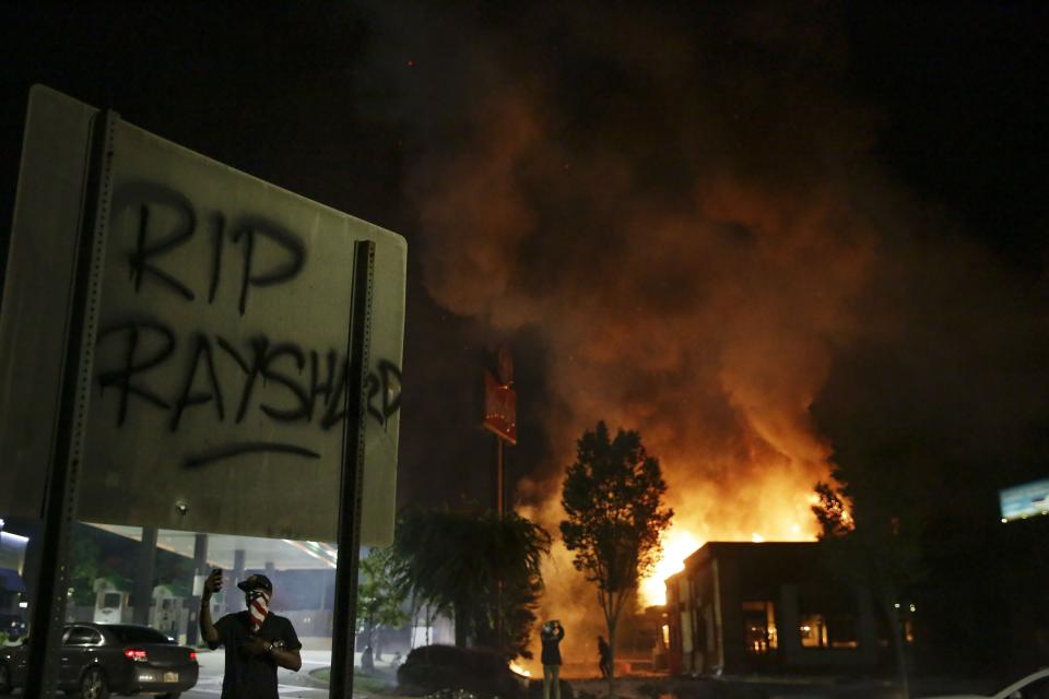 File-In this Saturday, June 13, 2020 file photo, "RIP Rayshard" is spray-painted on a sign as flames engulf a Wendy's restaurant where Rayshard Brooks was shot and killed by police in Atlanta. About five months before he was killed by Atlanta police in a Wendy's parking lot -- before his name and case would become the latest rallying point in a massive call for racial justice and equality nationwide – Brooks gave an interview to an advocacy group about his years of struggle in the criminal justice system. (AP Photo/Brynn Anderson, File)