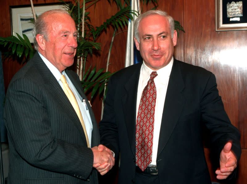 FILE PHOTO: Israeli Prime Minister Benjamin Netanyahu gestures towards the press as he shakes hands with former U.S. Secretary of State George Shultz at the start of their meeting