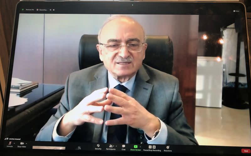 A photograph of a laptop screen shows LAU President Michel Mawad speaking during his online interview with Reuters, in Beirut