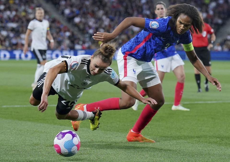 Germany&#39;s Lina Magull is challenged by France&#39;s Wendie Renard for the ball.