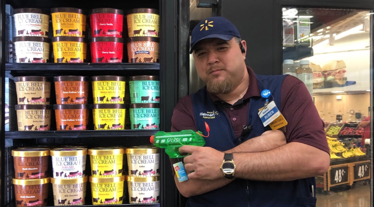 A Walmart employee guards a freezer of Blue Bell ice cream with a water gun after a viral video depicted a Texas teen licking the top of the ice cream and returning the carton to a freezer. (Photo: Facebook) 