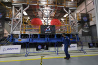 NASA astronaut Matt Dominick walks past NASA's Space Launch System (SLS) core stage and four attached rocket engines that will be used for the Artemis 1 mission, at the NASA Michoud Assembly Center in New Orleans, Monday, Dec. 9, 2019. (AP Photo/Gerald Herbert)