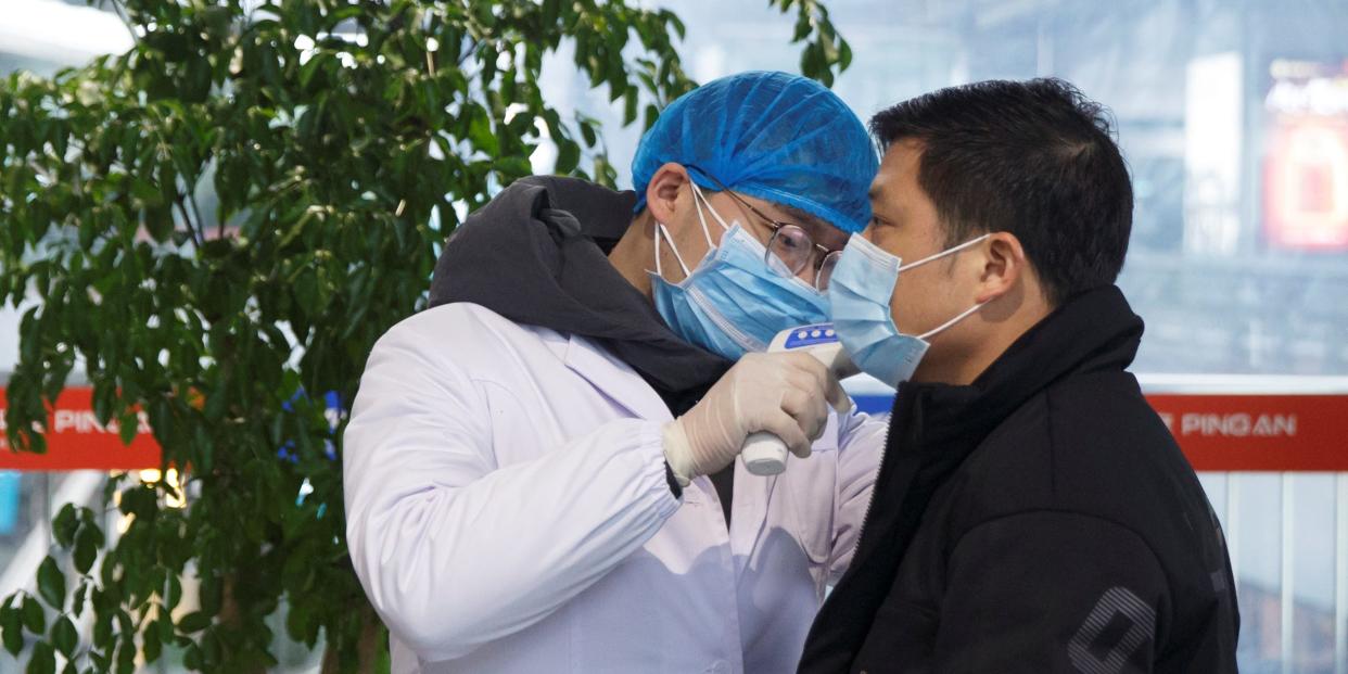 A medical official takes the body temperature of a child at the departure hall of the airport in Changsha, Hunan Province, as the country is hit by an outbreak of a new coronavirus, China, January 27, 2020.