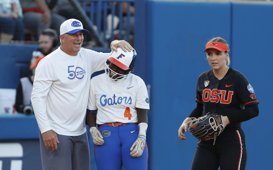 Florida coach Billy Napier and Charla Echols (4) celebrate after she reached third base during the fifth inning of an NCAA softball Women's College World Series game against Oregon State on Thursday, June 2, 2022, in Oklahoma City. (AP Photo/Alonzo Adams)