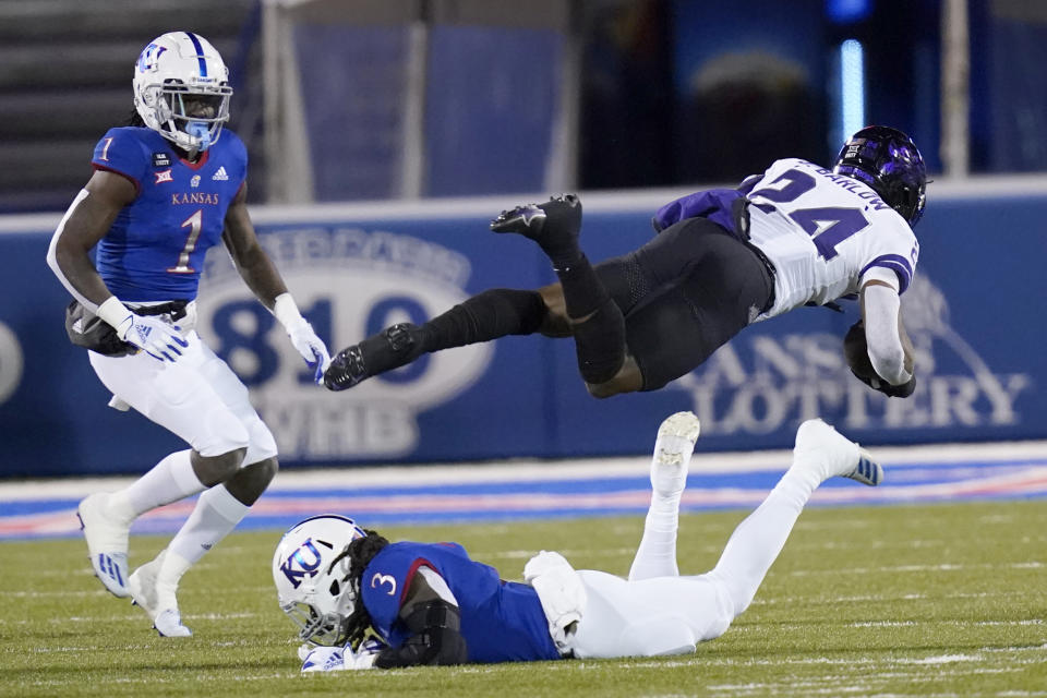 TCU running back Darwin Barlow (24) dives over Kansas safety Ricky Thomas (3) during the first half of an NCAA college football game in Lawrence, Kan., Saturday, Nov. 28, 2020. (AP Photo/Orlin Wagner)