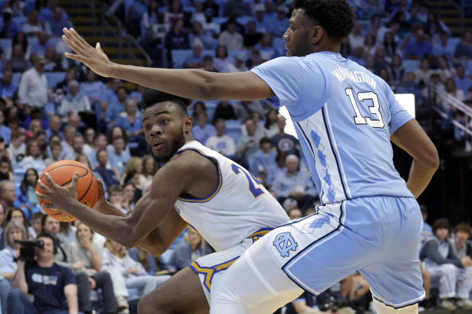 UC Riverside guard Barrington Hargress, left, looks to pass around North Carolina forward Jalen Washington (13) during the second half of an NCAA college basketball game Friday, Nov. 17, 2023, in Chapel Hill, N.C. (AP Photo/Chris Seward)