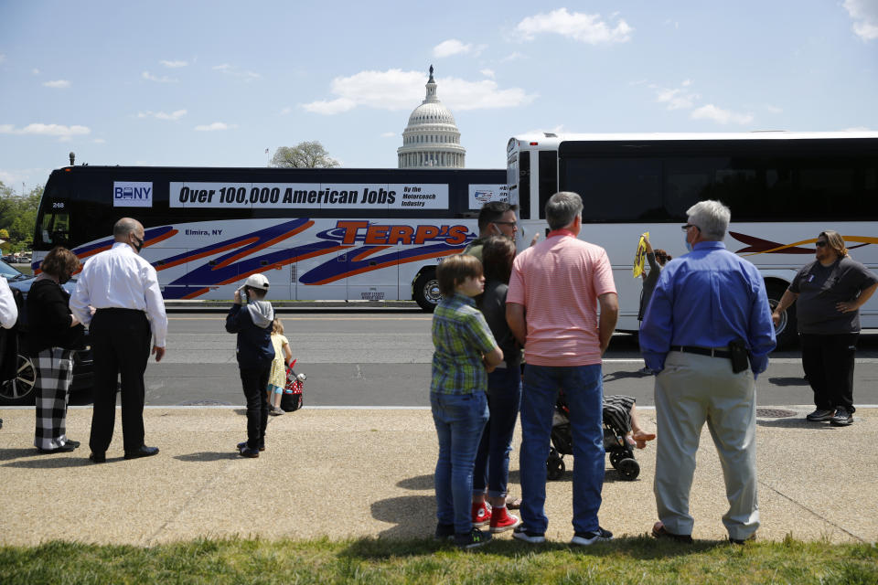 Buses and motor coaches circle past gatherers on the National Mall in Washington, Wednesday, May 13, 2020, as part of a rally to raise awareness of the industry in the wake of the coronavirus outbreak. (AP Photo/Patrick Semansky)