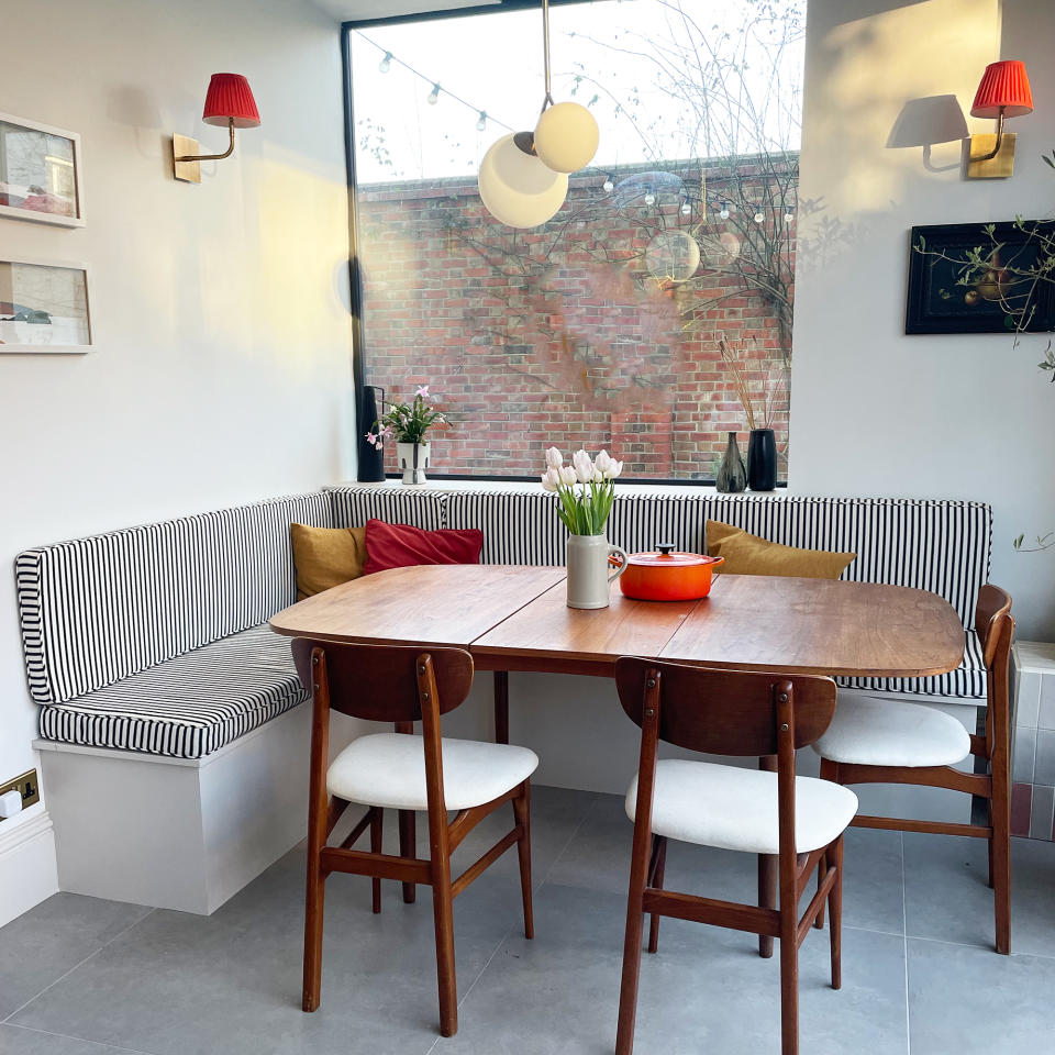 L-shaped kitchen bench seating with striped cushions and a picture window