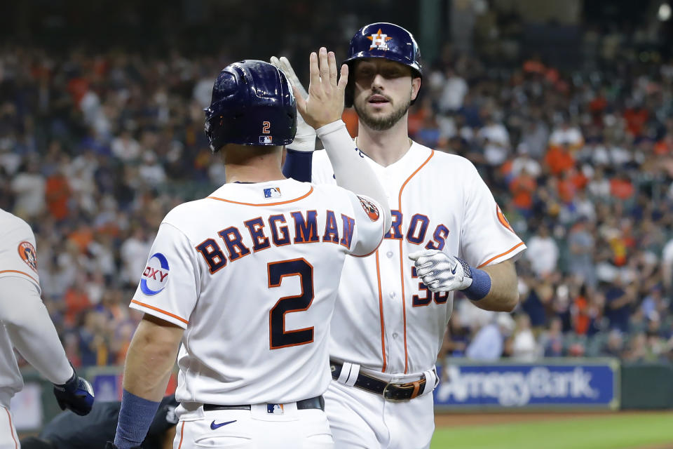 Houston Astros' Alex Bregman (2) and Kyle Tucker, right, celebrate after they both scored on the two run home run by Tucker against the Boston Red Sox during the first inning of a baseball game, Tuesday, Aug. 22, 2023, in Houston. (AP Photo/Michael Wyke)