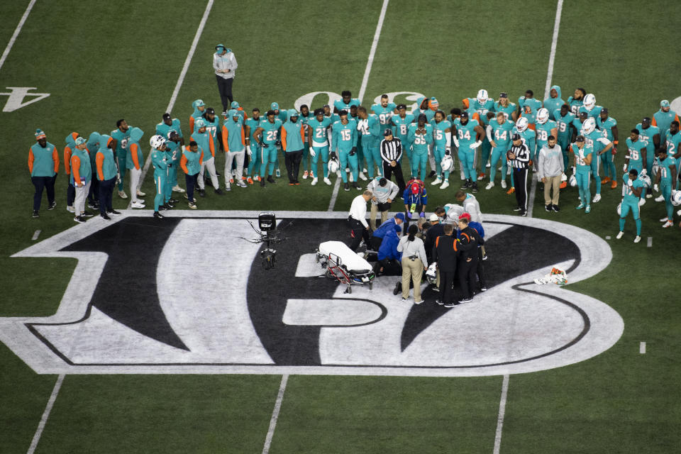 Teammates gather around Miami Dolphins quarterback Tua Tagovailoa (1) after an injury during the first half of an NFL football game against the Cincinnati Bengals, Thursday, Sept. 29, 2022, in Cincinnati. (AP Photo/Emilee Chinn)