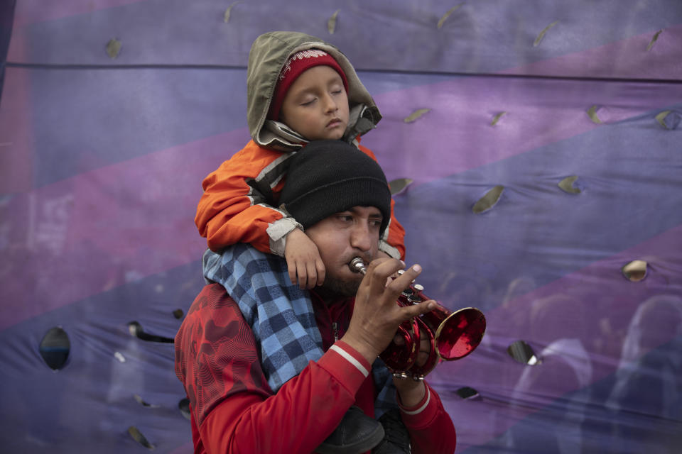 Un niño se queda dormido mientras su padre toca una trompeta durante una protesta para exigir más fondos para programas sociales en apoyo a los desempleados, el miércoles 10 de agosto de 2022, en Buenos Aires, Argentina. (AP Foto/Víctor R. Caivano)