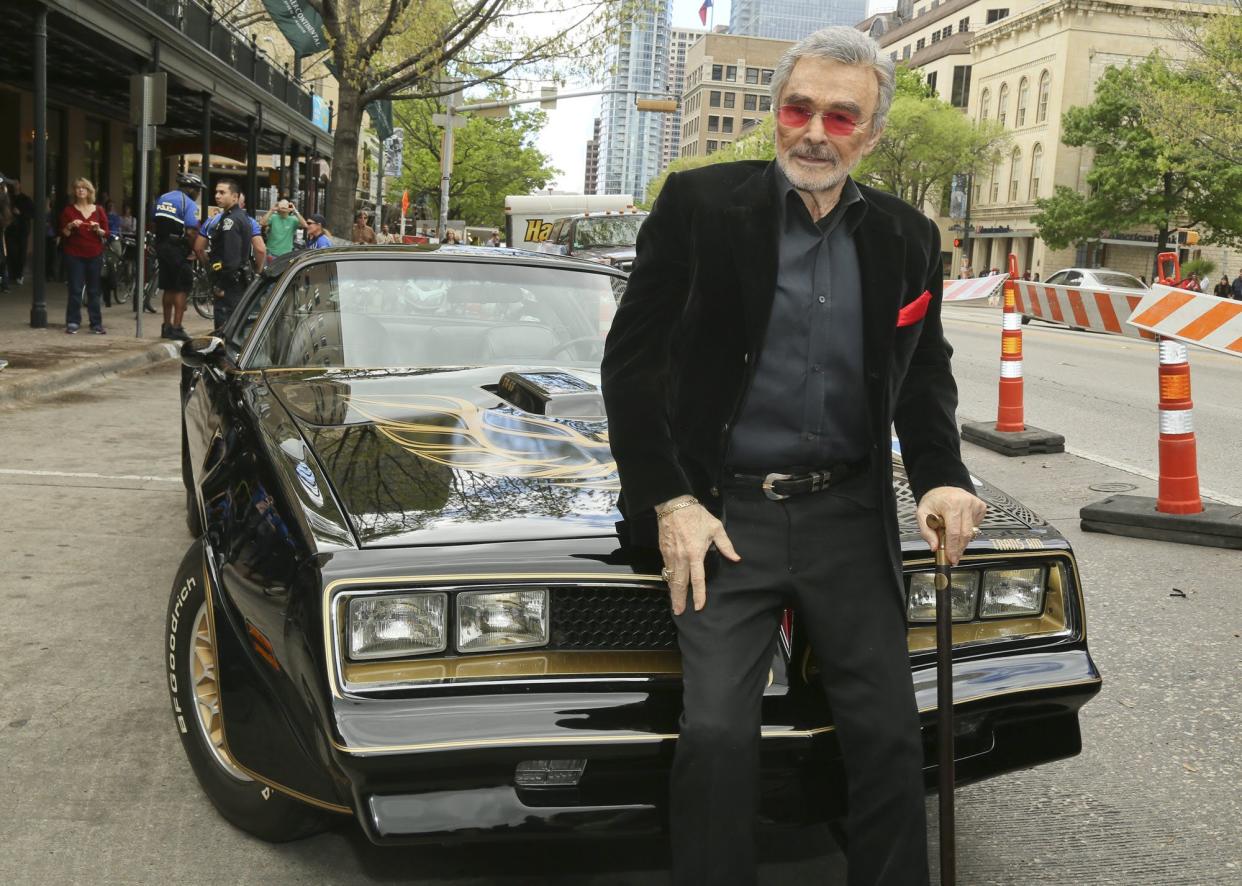 Burt Reynolds sits on a 1977 Pontiac Trans-Am