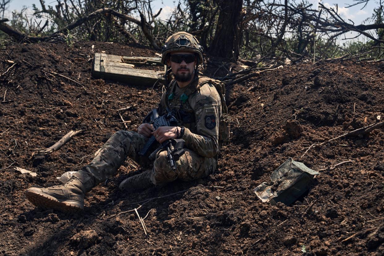 A Ukrainian soldier sits in a recently captured Russian trench on the frontline near Bakhmut, Donetsk region, Ukraine (AP)