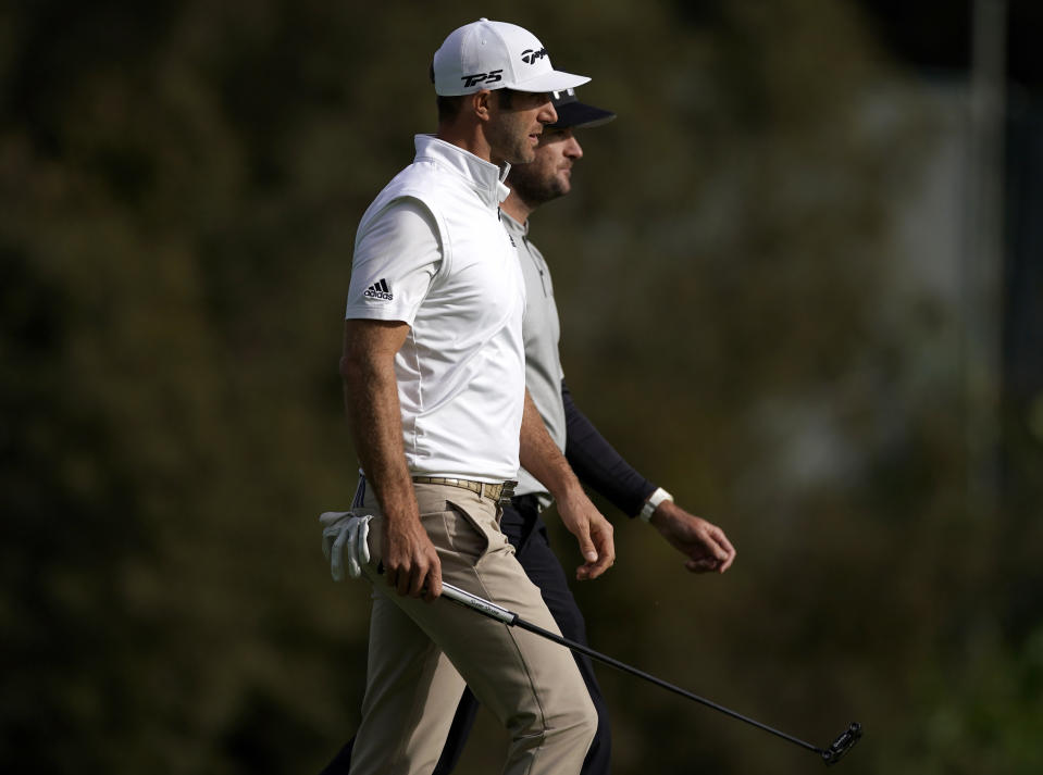 Dustin Johnson, front, and Bubba Watson walk in unison to the 13th green during the first round of the Genesis Open golf tournament at Riviera Country Club on Thursday, Feb. 14, 2019, in the Pacific Palisades area of Los Angeles. (AP Photo/Ryan Kang)
