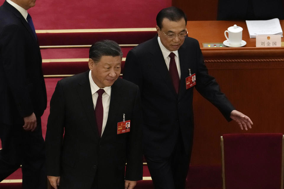 Chinese Premier Li Keqiang, right, walks near Chinese President Xi Jinping during the opening session of China's National People's Congress (NPC) at the Great Hall of the People in Beijing, Sunday, March 5, 2023. After a decade in Chinese President Xi Jinping's shadow, Li Keqiang is taking his final bow as the country's premier, marking a shift away from the skilled technocrats who have helped steer the world's second-biggest economy in favor of officials known mainly for their unquestioned loyalty to China's most powerful leader in recent history. (AP Photo/Ng Han Guan)