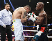 Floyd Mayweather Jr., right, trades blows with Marcos Maidana, from Argentina, in their WBC-WBA welterweight title boxing fight Saturday, May 3, 2014, in Las Vegas. Referee Tony Weeks is at left. (AP Photo/Eric Jamison)